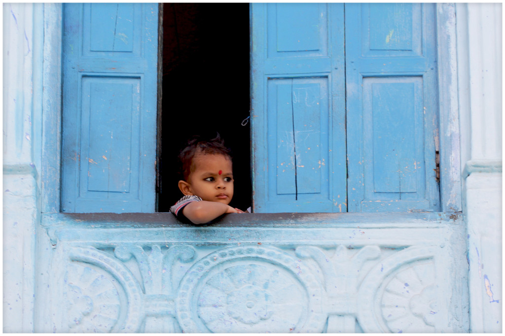 Little girl watching over the blue city